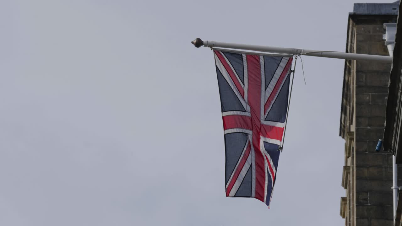 la bandera union jack ondeando fuera de un edificio del gobierno