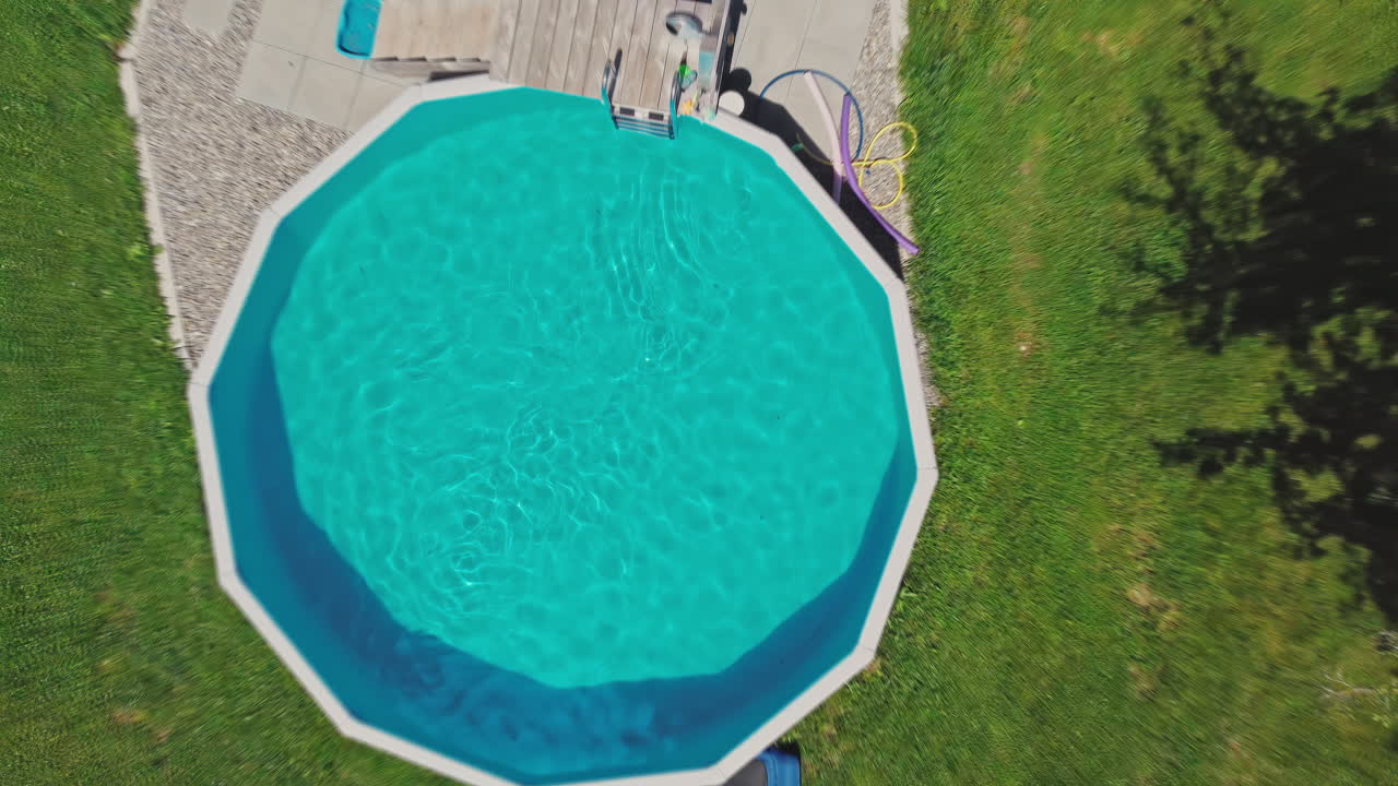 Droneoptagelse, der kigger ned på en lille pool på en solrig dag