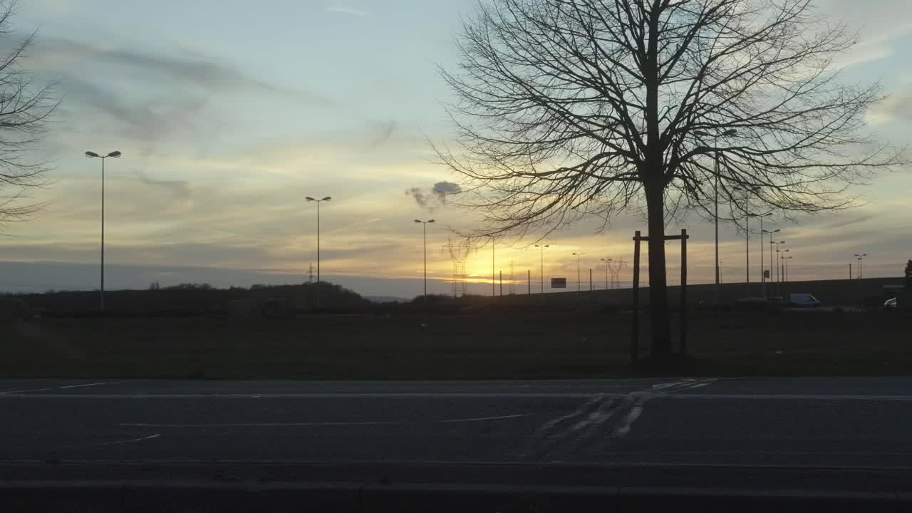 경이로운 불과 함께 주차장에 wispy 나무 해가 지는 실루 뒤에 구름 풍경