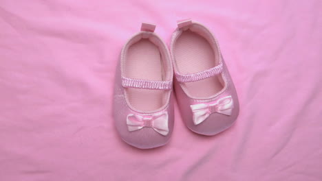 pink baby booties on pink blanket