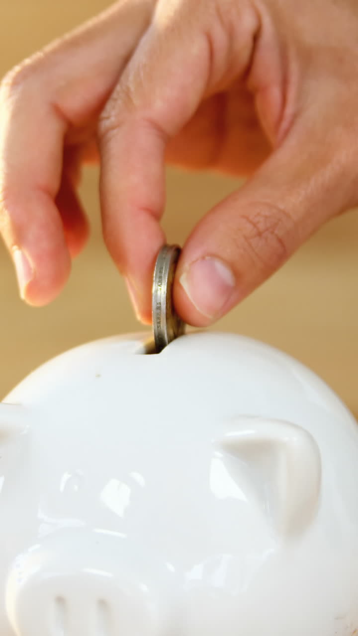 Woman putting coin in piggy bank