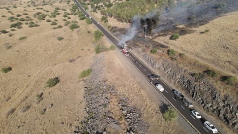 Emergency-vehicles-arriving-at-burning-passenger-bus-accident,-aerial-drone-view