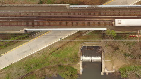 a top down, drone view over a small water runoff for a lake on a cloudy day