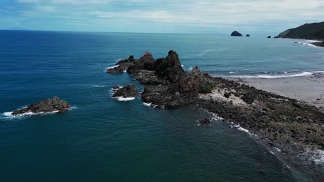 a dynamic drone shot sweeps in from a lower angle, capturing the rugged beauty of the rocky mountains rising dramatically from the shoreline.