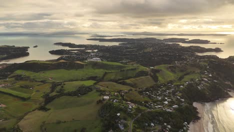 onetangi beach with cloudy sky, waiheke island, new zealand. aerial drone panoramic view at dusk