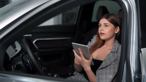 bella joven recibe un mensaje alegre por teléfono mientras está sentada en el auto