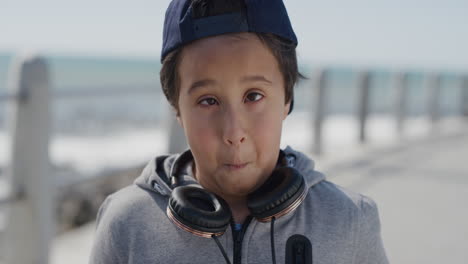 portrait young happy boy smiling making faces naughty kid enjoying summer vacation on warm seaside beach slow motion