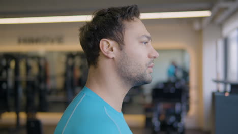 Bearded-Fit-Man-Running-on-Treadmill-in-Gym,-Jogging-in-Slow-Motion---Face-Profile-Close-up