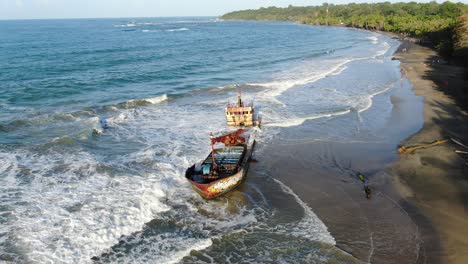 vista de drones de la playa de costa rica que muestra el mar, la costa y un barco varado en un día soleado sobre el océano atlántico en el caribe