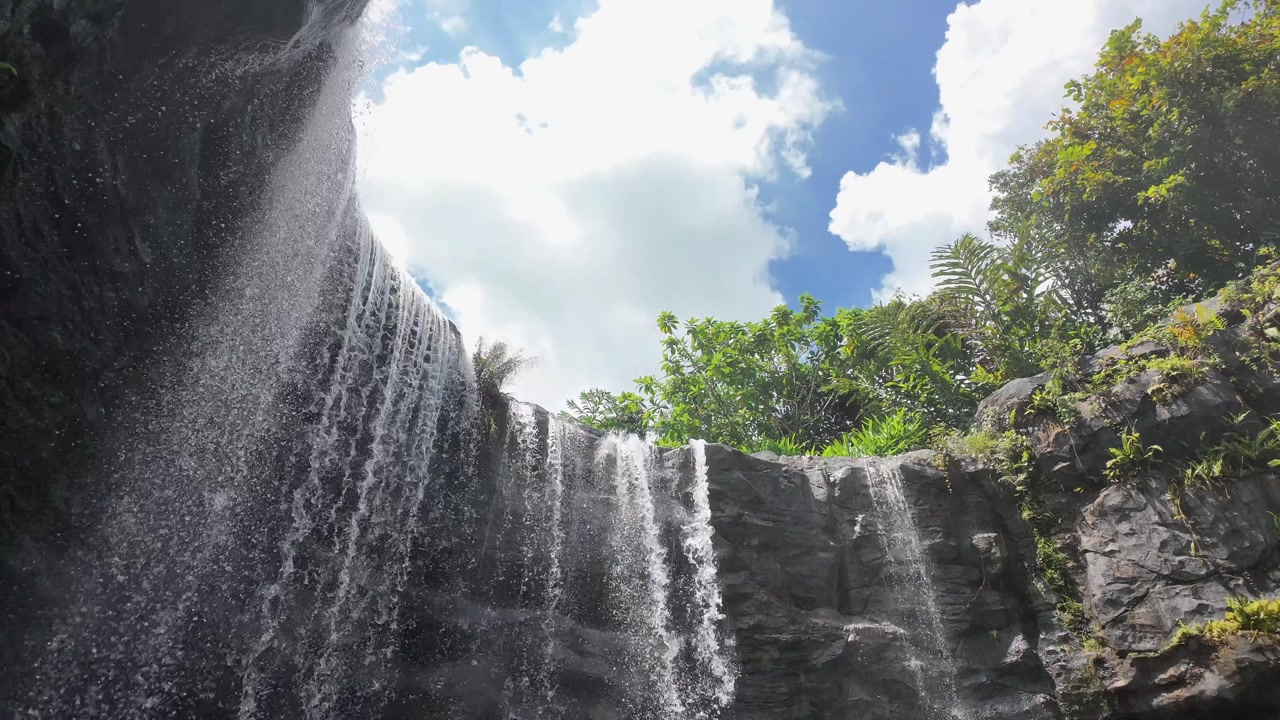 Majestic Tropical Waterfall Cascading Down a Rocky Cliff