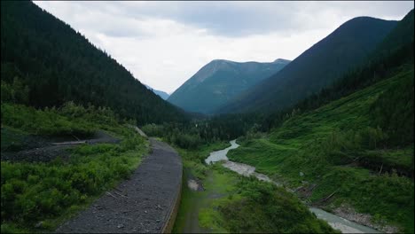 slow rise above an avalanche shelter beside a cold mountain river