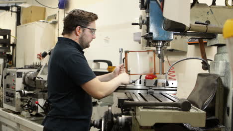 man operating a milling machine in an industrial workshop, focused on his task