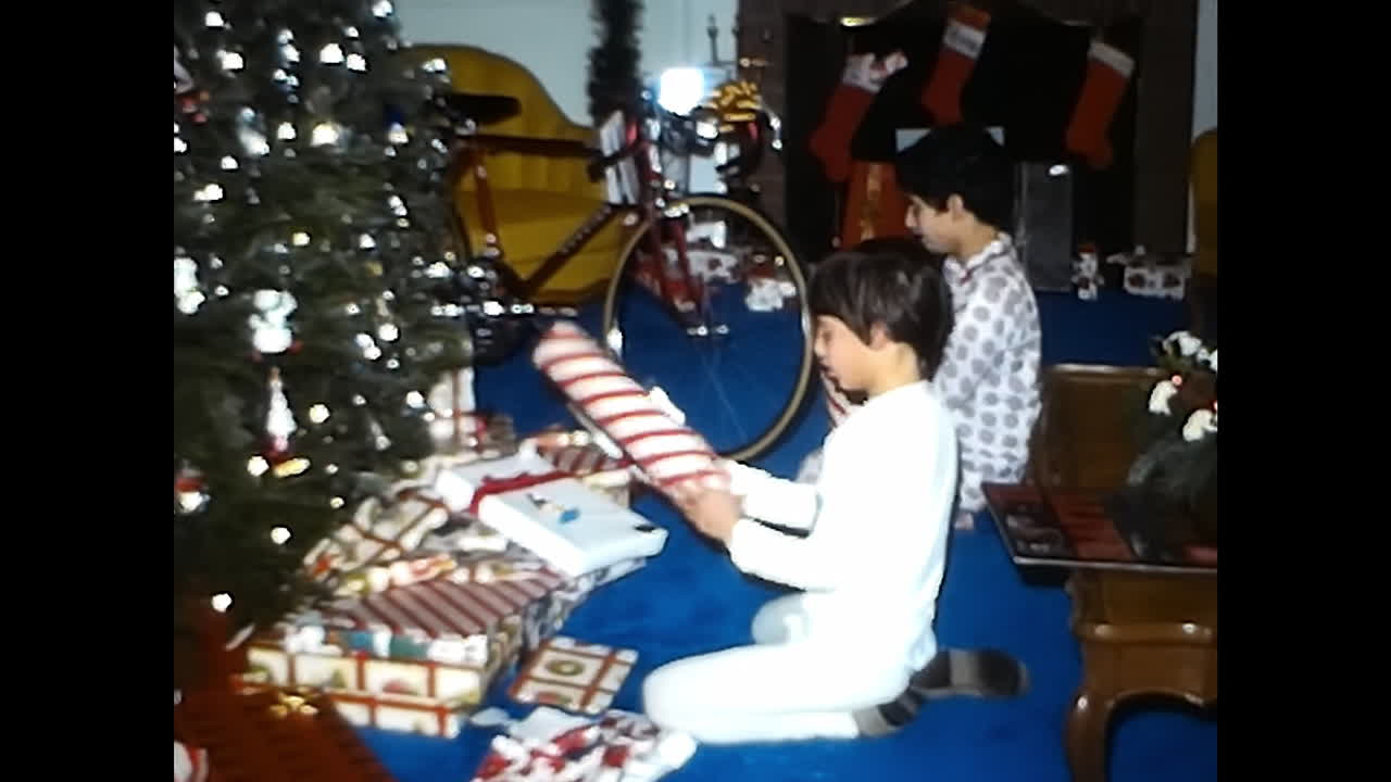 Couple Standing Next to Christmas Tree. CIRCA USA - 1970s: A couple from a 1970s video archive in the USA standing next to a Christmas tree.