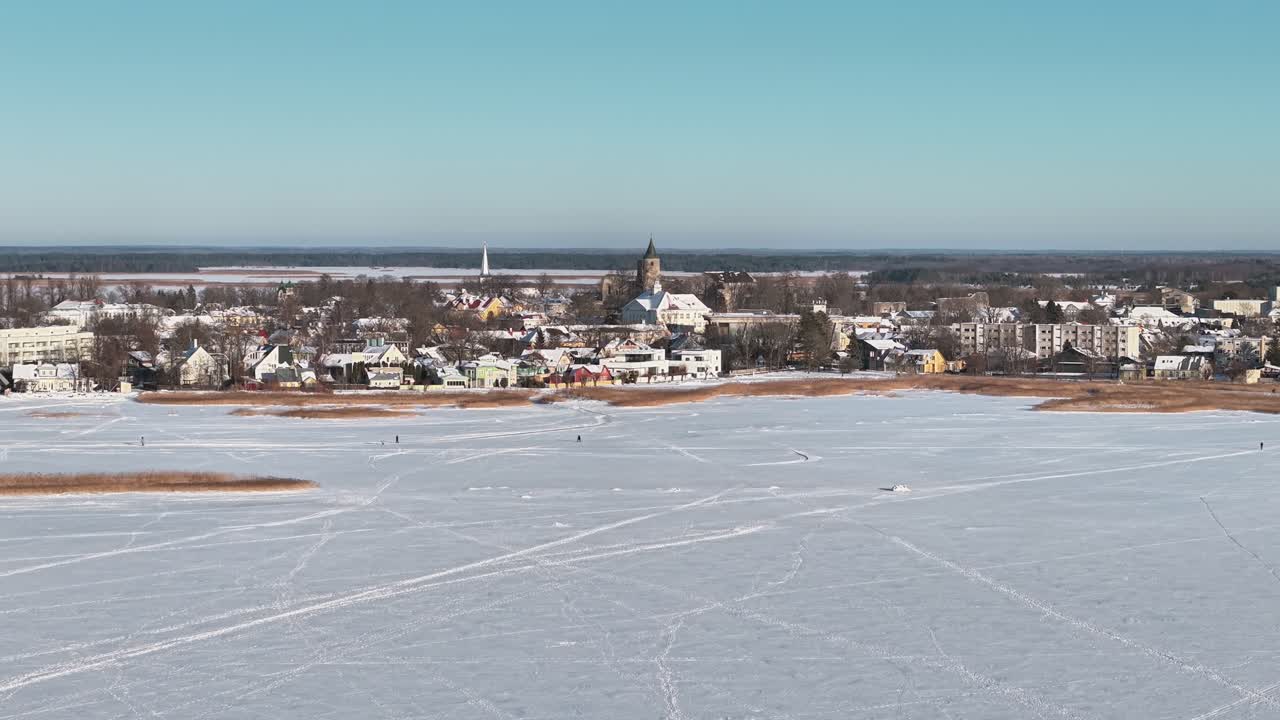 Lac gelé au premier plan avec les bâtiments de la ville de Haapsalu et une église en Estonie.