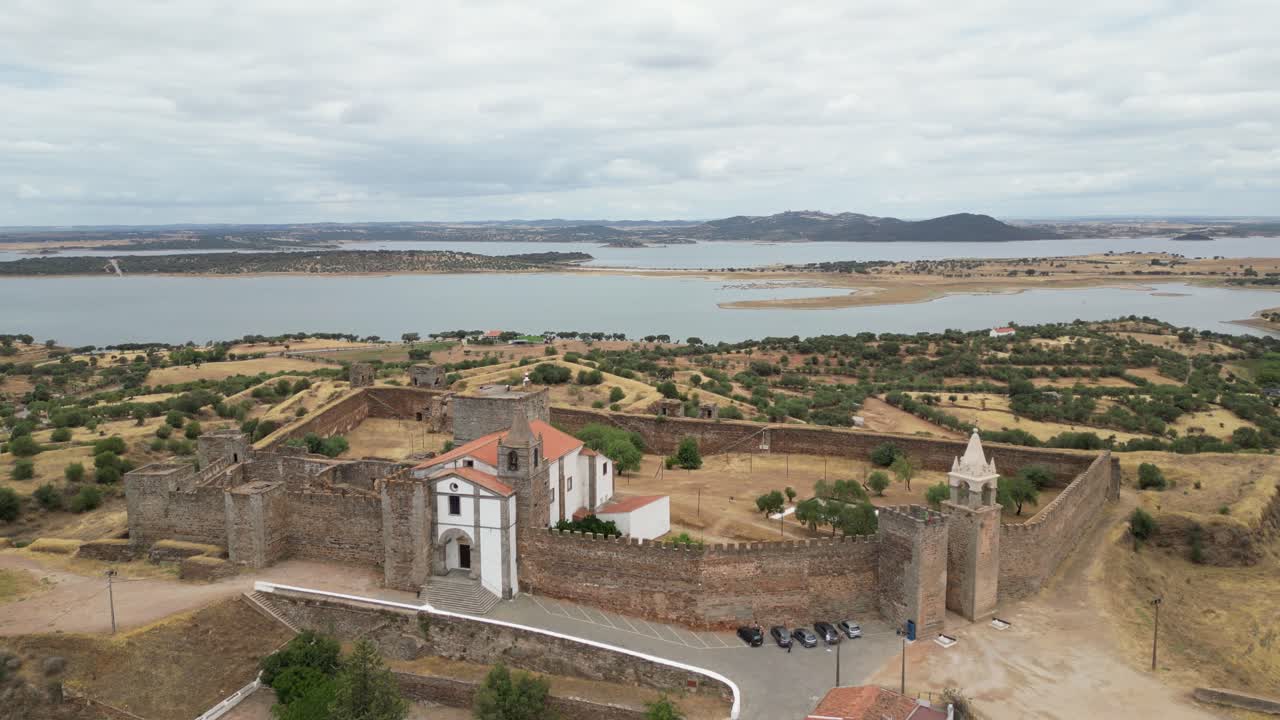 Vista aerea orbitante della fortezza di Mourão, paesaggio unico dell'Alentejo con il lago Alqueva che si estende