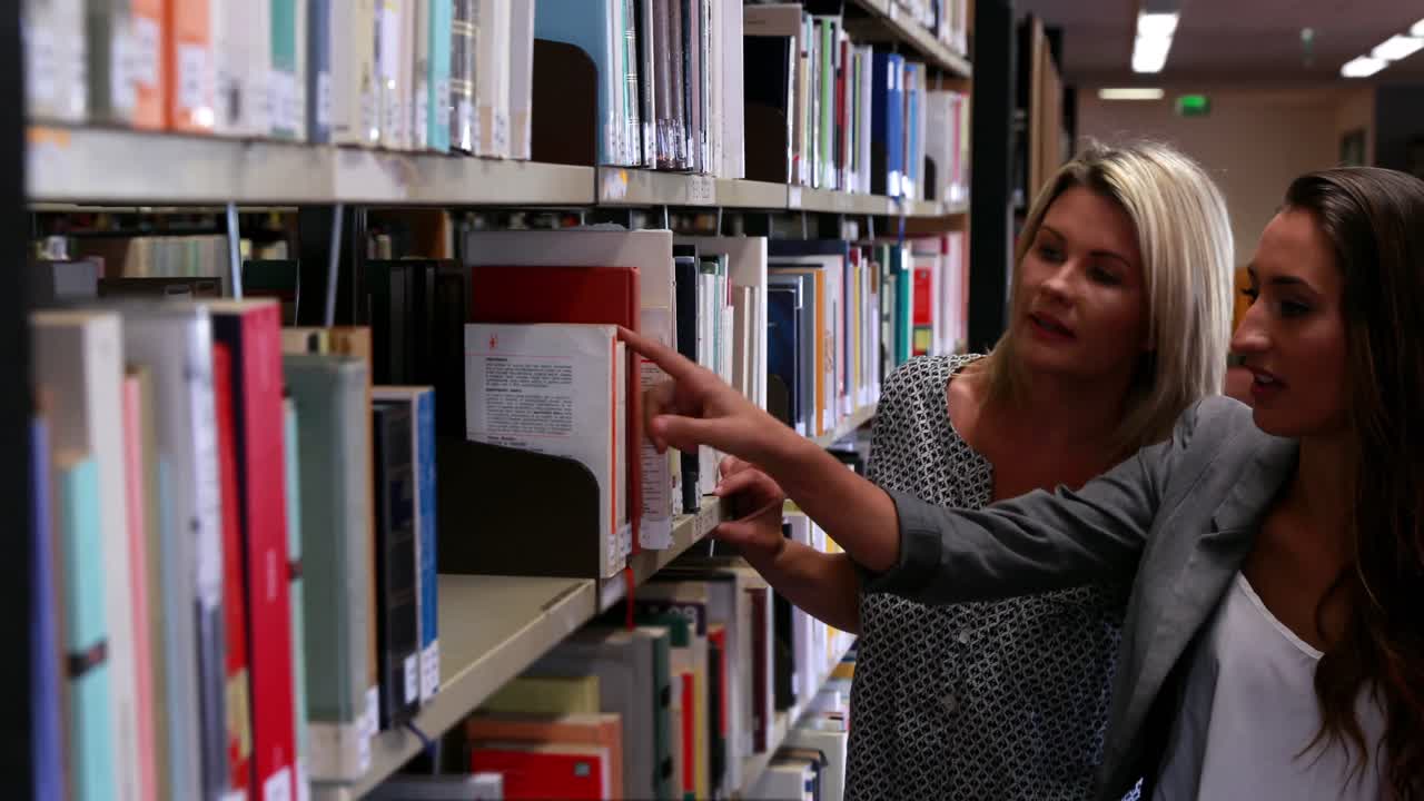 retrato de estudiantes eligiendo un libro en un estante