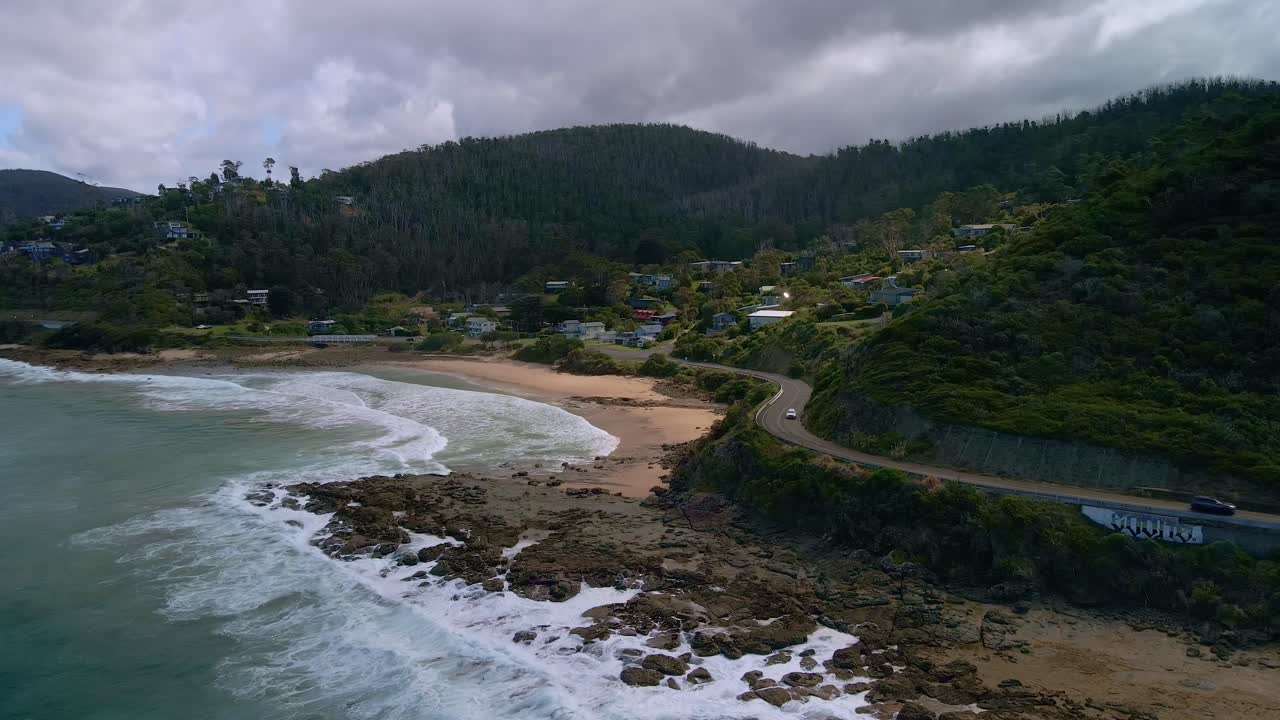 hermosa toma aérea de la sinuosa great ocean road de victoria con la ciudad de separation creek y el cielo nublado y los rayos del sol, australia