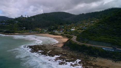 Beautiful-aerial-shot-of-Victoria's-winding-Great-Ocean-Road-with-town-of-Separation-Creek-and-cloudy-sky-and-sun-rays,-Australia