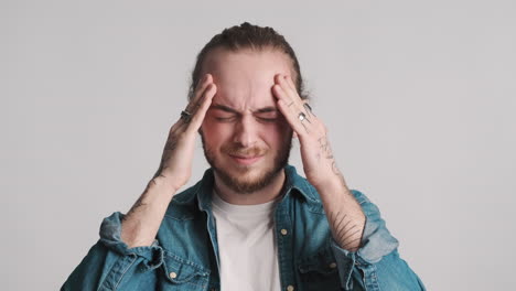 caucasian young man showing headache.