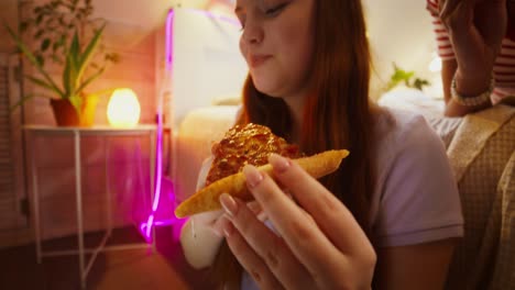 chicas adolescentes comiendo pizza en su dormitorio