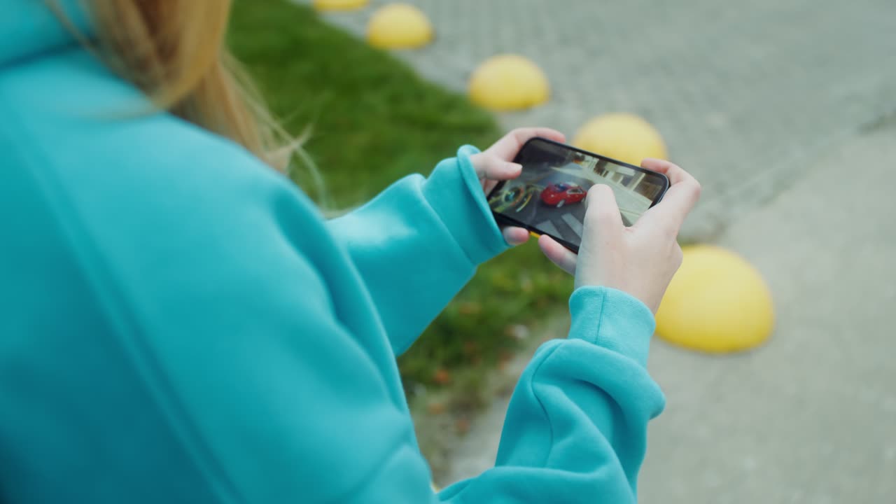 Girl playing a mobile game on her smartphone outdoors