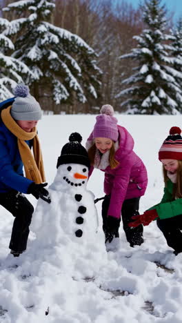 children playfully building and destroying a snowman in winter