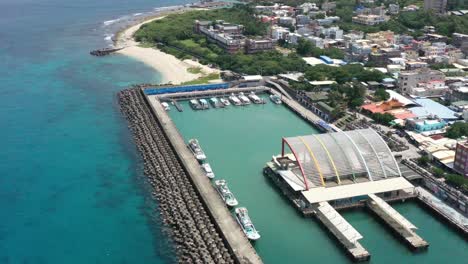 aerial view of baishawei fishing harbor terminal surrounded by wave breaker walls, beautiful townscape of fisherman village and turquoise seascape, xiaoliuqiu lambai island, pingtung county, taiwan