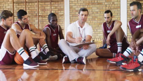 coach explaining game plan to basketball players