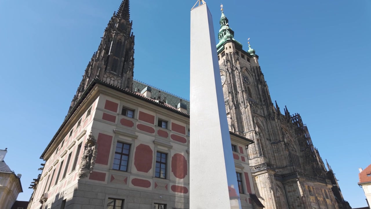 St. Vitus Cathedral and nearby architecture under a bright blue sky in Prague