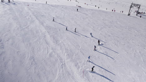 row of people skiing down a ski slope on kizsteinhorn mountain in austria in winter