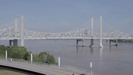 Panoramic-of-Second-Street-Bridge-over-the-Ohio-River-in-Louisville,-Kentucky-with-pedestrian-bridge-in-foreground-and-downtown-city-skyline-in-the-background