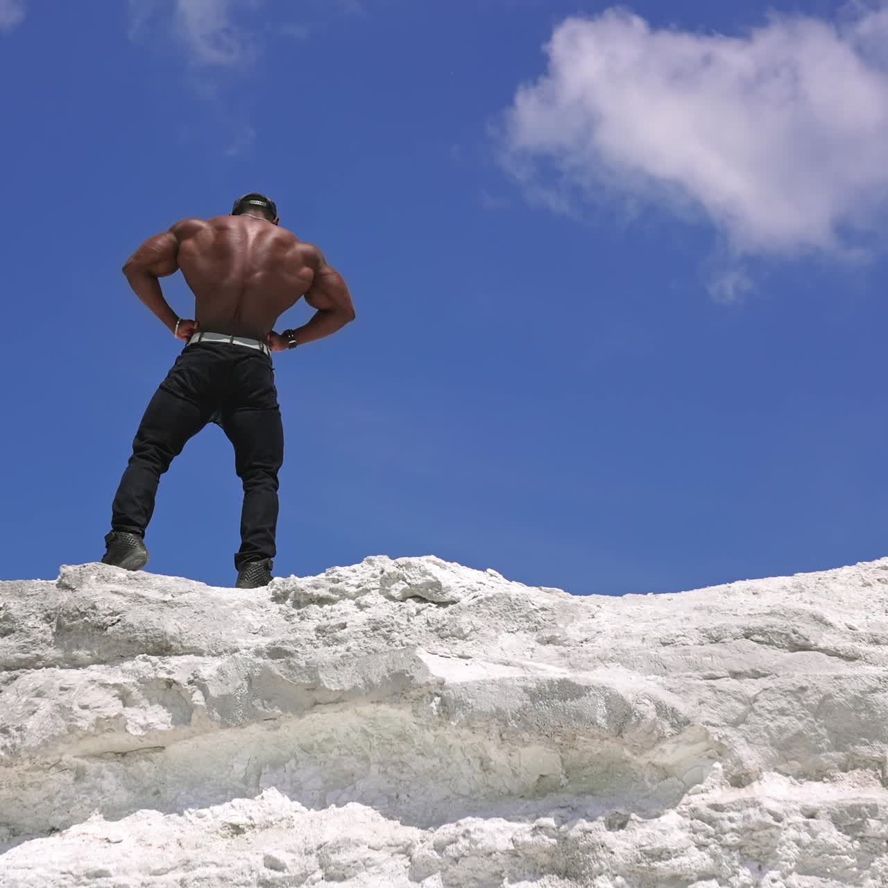 Strong athletic male model portrait. African american man bodybuilder posing on the rock