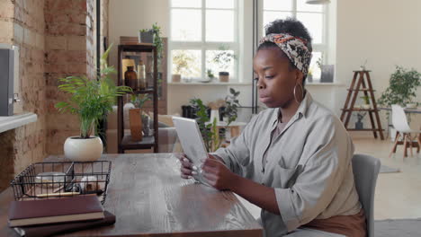 busy african-american woman using tablet at home