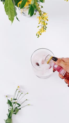 pouring a rosé cocktail with flowers