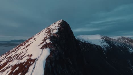 reaching snow covered mountain peek with fpv drone view