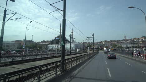 el taxi pov atraviesa el puente galata hacia el corazón de estambul. la mezquita yeni en el lado antiguo de estambul