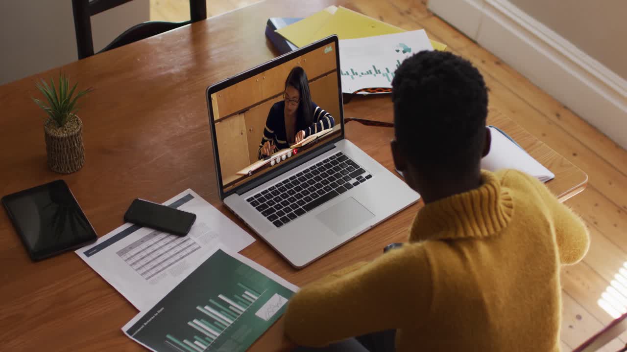 African american female teacher using laptop on video call with female student