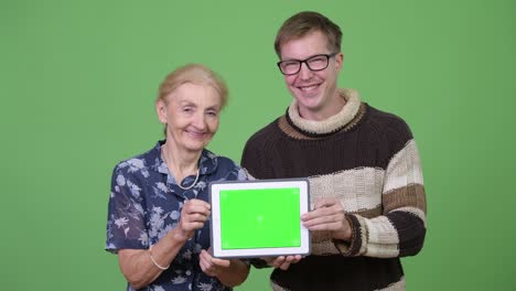 happy grandmother and grandson showing digital tablet together