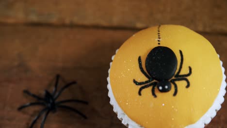 Halloween-spider-cupcake-on-a-wooden-table-4k