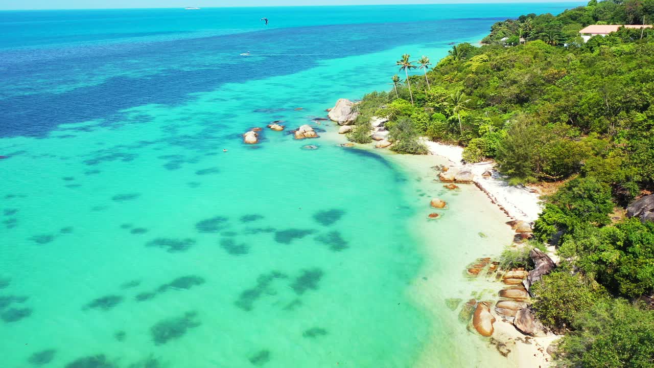 Parasailing su una splendida laguna tranquilla con barriere coralline sott'acqua, spiaggia esotica con sabbia bianca delimitata da piante tropicali e mare turchese, Ko Phangan, Thailandia