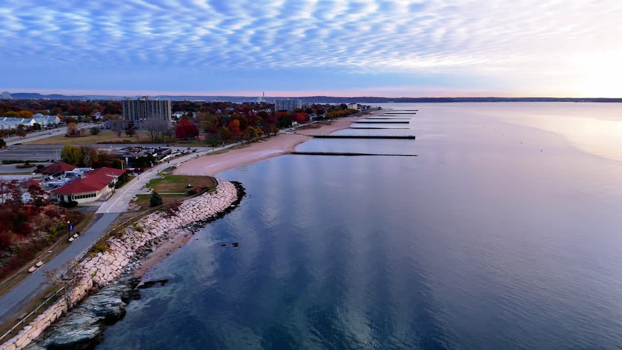 Aerial view of a beach with breakwaters at sunrise