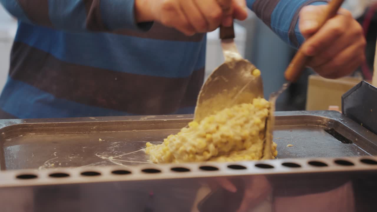 Taiwanese street food vendor grills yummy cheesy corn to perfection, blending creamy toppings with smoky flavors in a bustling night market setting