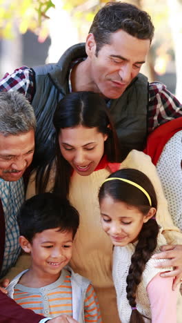 família de várias gerações a tirar uma selfie no parque.