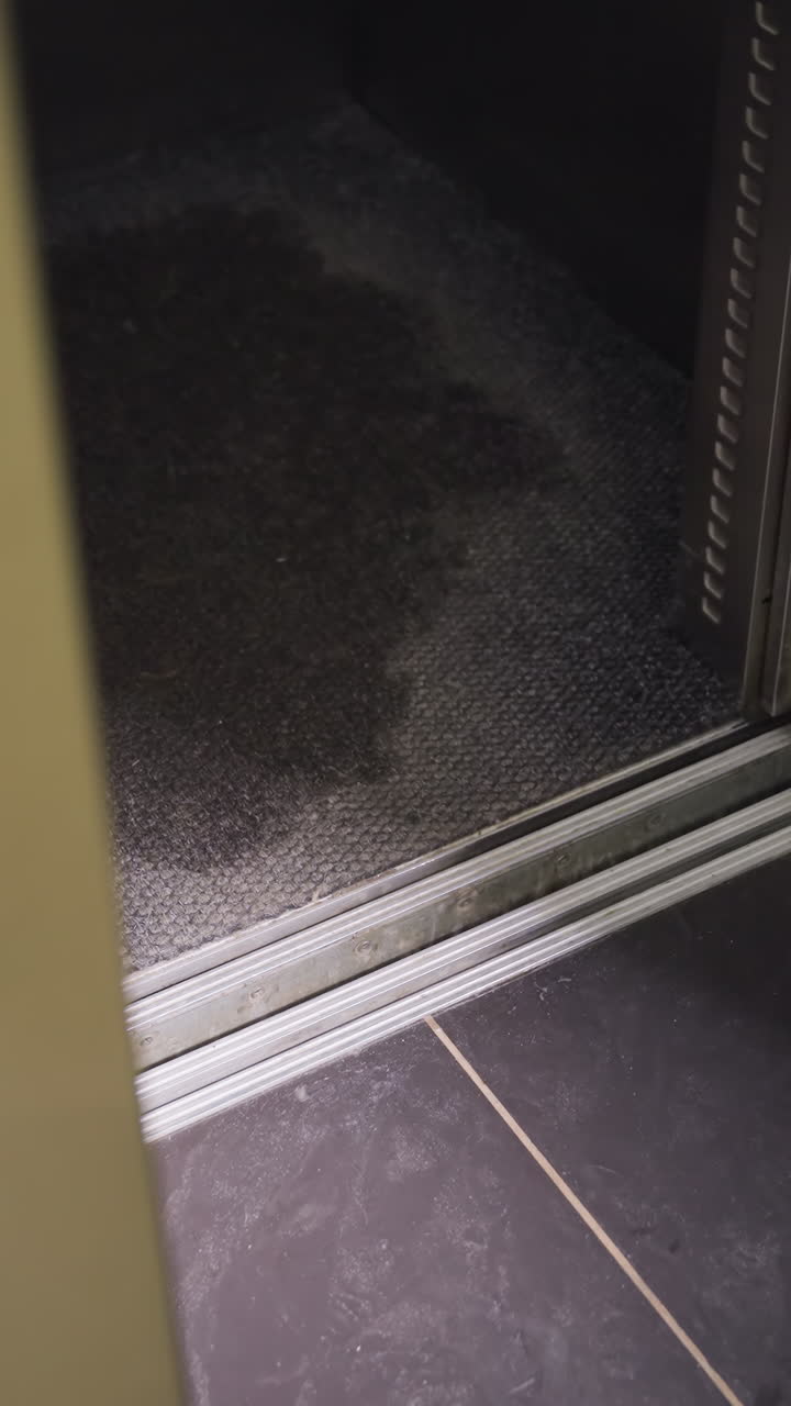Close-up of woman's foot stepping out of elevator, professional office attire, gray high heels, corporate building, clean floor, exit from elevator, modern design, office environment