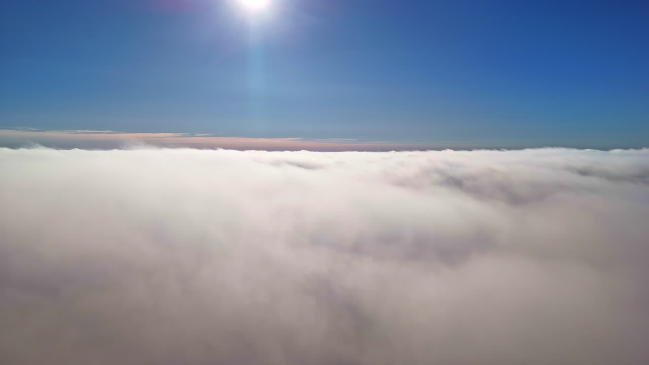 Aerial view above the cloud cover under a blue sky