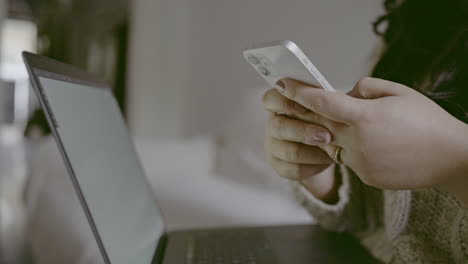 mujer usando teléfono inteligente y portátil