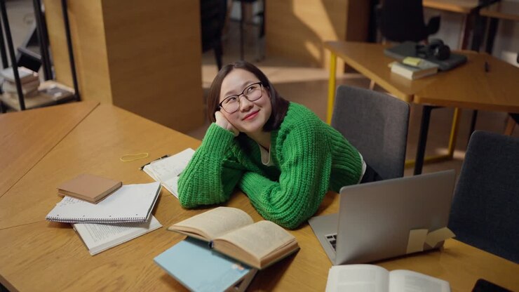 La donna che studia in biblioteca