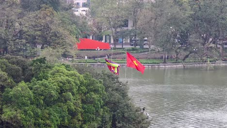 banderas ondeando cerca de un lago en hanoi