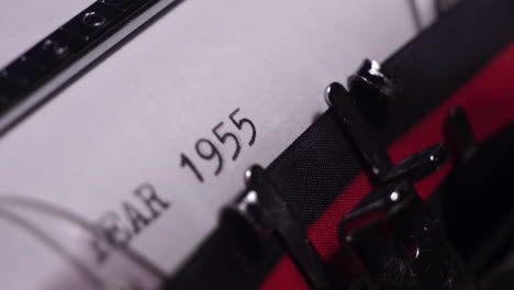 year 1955, typing on white paper in vintage typewriter, close up