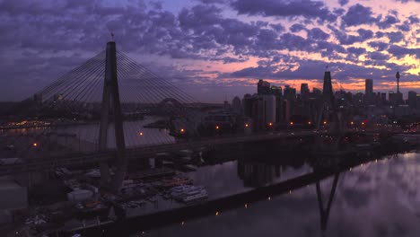 Drone-aerial-view-of-traffic-flowing-over-a-suspended-bridge-across-a-river